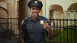 © Krakenimages.com - Man police officer holding a takeaway coffee cup, smiling and offering cup at building entrance with iron fence and archway; friendly community trust.