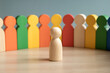 © Nazmul Karim Sakib - Single wooden peg person figure standing in front of a colorful diverse group with public speaking decision maker standing individuality community management leadership representation abstract