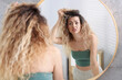 © New Africa - Unhappy woman with tangled hair near mirror in bathroom