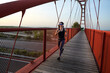 © FotoAndalucia - woman with sunglasses running on a bridge