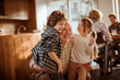 © Geber86 - Smiling grandfather hugging grandchildren at home kitchen