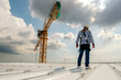 © Rassarin - Construction engineer wear safety uniform inspection metal roofing work for roof industrial concept with copy space