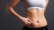 © Keopaserth - Abdominal fat female body hand skin torso waist fitness weight loss health slim body body fat abdomen stomach belly navel skin fold pinch figure young adult woman white top black pants isolated