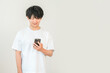 © buritora - A young Asian man using a smartphone (searching/researching)