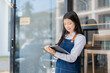 © maeching - A waitress stood at the entrance of the coffee shop.