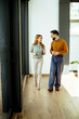 © BGStock72 - Two colleagues engage in a friendly conversation while walking indoors together