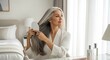 © postproduction - Middleaged Woman Styling Silver Hair with Brush in Bedroom
