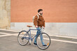 © Oscar - Young man walking a bicycle in urban setting
