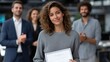 © Oulaphone - A confident young woman holds a certificate while three colleagues applaud her achievement in a professional indoor setting.