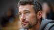 © Darya - Coach focuses closely on strategy during practice session at sports facility in the evening