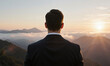 © panophotograph - Businessman sunrise mountain peaks view overlooking clouds during golden hour symbolizing success and leadership vision