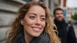 © Bussakon - A joyful portrait of a smiling young woman with blonde hair set against a subtle modern urban background