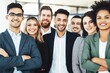 © Juan - Diverse business team posing together smiling representing teamwork success leadership and inclusive workplace culture