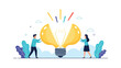 © Jayed - Creative team of a man and a woman opening a giant glowing lightbulb to discover new business ideas and solutions.