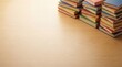 © Haven - Colorful stacks of hardback books arranged on a light wooden table background
