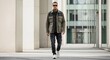 © D-point - Young man with tattoos and sunglasses walking in urban environment. Stylish male model demonstrating casual fashion. Modern street style for youth.