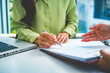 © MIND AND I - Close-Up of Businesswoman Hands Holding Pen to Sign Contract at Desk
