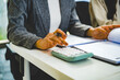 © MIND AND I - Close-Up of Businesswoman Hands Using Calculator and Reviewing Documents