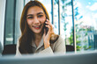 © MIND AND I - Smiling Asian Businesswoman Talking on Smartphone in Office