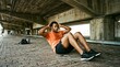 © Wati - Male Runner Doing Sit ups Under Bridge in Urban Environment