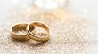 © Ekaterina - close-up of two golden wedding rings resting on sparkling glitter with elegant bokeh background. perfect for wedding-themed visuals, invitations, and jewelry advertisements