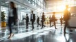 © Farah - A bustling office lobby with people walking quickly past glass walls and large windows at sunset