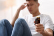 © New Africa - Depressed man with antidepressant pills at home, selective focus