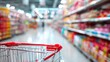 © VICHIZH - Shopping cart in supermarket aisle with blurred shelves full of products, groceries, and food items for retail shopping and consumer purchase experience.