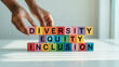 © vibsensie - Hands arranging colorful blocks spelling diversity equity inclusion symbolizing ecological sustainability and green energy