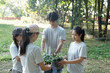 © Wanda - Asian people holding seedlings stand in a circle