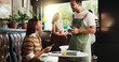 © peopleimages.com - Woman, credit card and waiter with pos at coffee shop, order and happy customer experience at diner. People, server and smile with easy payment at cafe, fintech or machine with thanks at restaurant