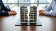 © solom - Two business people sitting at a table with a split building model representing divorce settlement and real estate property division