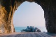 © pham - 洞窟の開口部から海と岩に向かう眺め