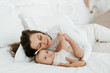 © Any Grant - mother with a baby in her arms, a loving single mother gently hugs and kisses her little child at home, motherly love and care, a happy mother with a baby.