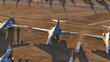 © AmazingAerialAgency - Tucson, United States - 06 February 2025: Aerial view of numerous grey warbirds resting on the vast, ochre desert floor, casting long, stark shadows under the golden light.