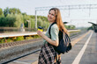 © Westend61 - Commuter with backpack and coffee waiting on railway platform