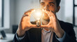 © Mehedi - Inspired businessman holding glowing light bulb with both hands as symbol of innovation new creative idea and visionary thinking within bright indoor office environment.
