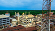 © AmazingAerialAgency - Aerial view of a majestic mosque with golden domes contrasting with rusty roofs and a communication mast against a verdant backdrop, Igbaja, Nigeria.