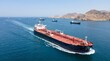© Design Stock - Massive oil tanker navigates azure waters leaving a white wake near a coastal mountain range