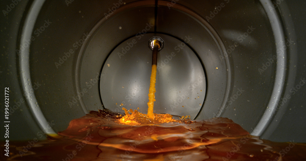 Gasoline jet pouring into metal fuel tank, inside view with dynamic ...