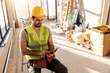 © milanmarkovic78 - Construction worker uses a tablet while sitting in a work area during daylight hours on a job site