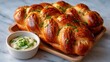 © svastix - A freshly baked braided bread, golden and fluffy, presented on a wooden platter with a small bowl of creamy butter, perfect for showcasing delightful culinary creations.