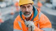 © Alper - Experienced construction worker with gray beard and yellow hard hat on a job site