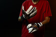 © Wavebreak Media - African American female adjusting white goalkeeper glove straps while wearing red jersey in studio