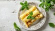 © Chingiz - Delicious crepes with mint sit on a white tiled table, seen from above.