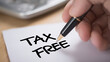 © photo for everything - Person write 'TAX FREE' on white paper with a pen, close up view concept for financial benefits, special offers, duty exemption, or shopping promotions
