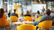 © ruben - Diverse group of people attending a business seminar in a modern conference room with yellow chairs.