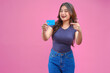 © ChristyMerry - Cheerful young Asian girl in a blue shirt is pointing to the credit card she holds.