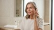© Frame of the Dark - Beautiful mature woman with glowing skin touching her face in bathroom, senior skincare and wellness