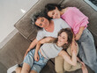 © Westend61 - Mother cuddling with daughters on couch showing family affection